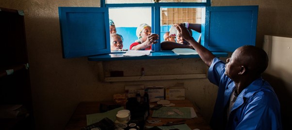 A pharmacist distributing medication through a window