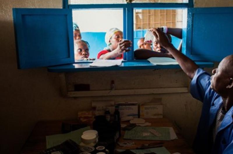 A pharmacist distributing medication through a window